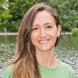 Women with brown hair and green jumper smiling.